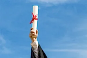 Mavi gökyüzüne doğru uzatılmış, kırmızı kurdeleyle bağlanmış bir diploma rulosu, mezuniyet ve akademik başarıyı simgeleyen görsel.