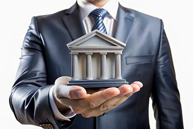 Takım elbiseli kişi elinde adliye biçiminde banka maketi tutuyor – kredi sözleşmeleri, dosya masrafları ve bankacılık hukuku danışmanlığı.