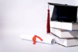 Kitap yığını üzerindeki mezuniyet kepi ve kırmızı kurdeleli diploma – yurt dışı denklik başvurusu ve STS sınavı iptal davası.