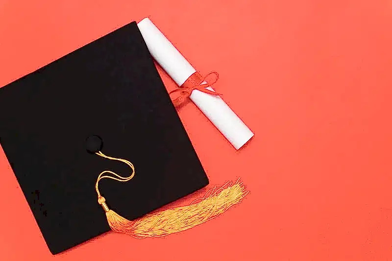 Kırmızı zemin üzerinde mezuniyet kepi ve diploma – diploma denklik davası ve akademik başvuru iptali hukuku.