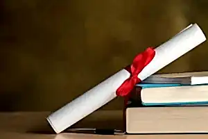 Kırmızı kurdeleyle bağlanmış bir diploma rulosu, yanında bir yığın hukuk kitabı ve bir kalemle akademik başarıyı ve hukuki eğitimi temsil eden görsel.