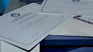 Üzerinde "LİSANS DİPLOMASI" yazan birkaç üniversite diplomasının yakından çekim görüntüsü, akademik başarıyı ve hukuki eğitimi temsil eden görsel.