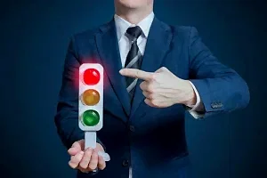 Kırmızı ışığı gösteren takım elbiseli kişi – hukuka aykırı trafik cezalarına itiraz süreci ve avukat desteği.