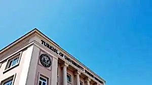 Tabelasında "Turkish University" yazan bir bina ve mavi gökyüzü.