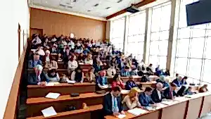 Üniversite sınav salonunda doçent adayları ve akademisyenler