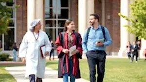 Profesör ve doçentlerin üniversite kampüsünde yürüdüğü görsel.